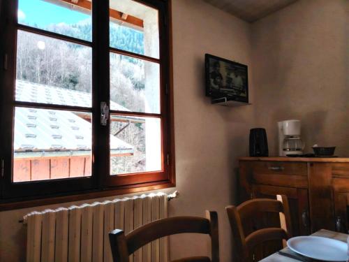 Habitación con ventana, mesa y sillas en Les Oulles 19, en La Chapelle-en-Valgodemard