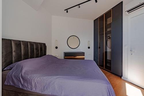 una camera da letto con un letto grande e uno specchio di Sunshine Appartement Budva a Bečići