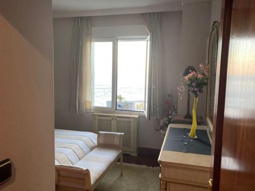 sypialnia z dwoma łóżkami i oknem w obiekcie APARTAMENTO UXUE. w mieście Mundaka