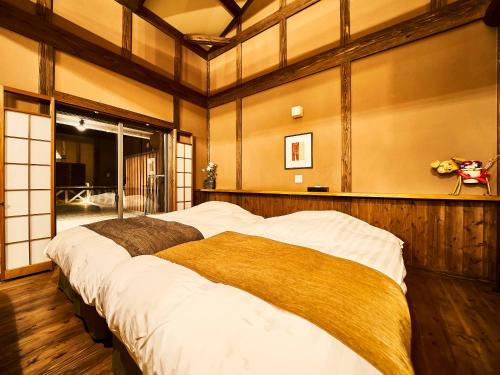 a bedroom with a large bed in a room at あさぎり山荘ひばり in Asagiri