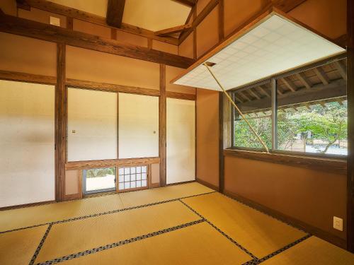 an empty room with two windows and a tiled floor at あさぎり山荘ひばり in Asagiri