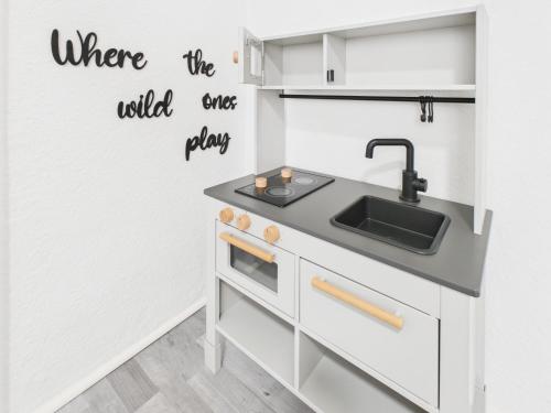 a kitchen with white cabinets and a sink at Loft & Living am Geiseltalsee in Braunsbedra