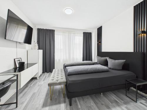 a black and white bedroom with a bed and a desk at Loft & Living am Geiseltalsee in Braunsbedra