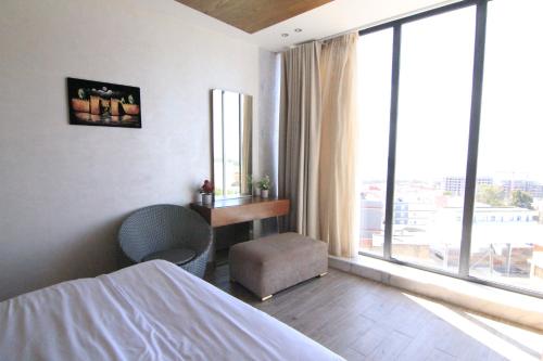 a bedroom with a bed and a desk and a window at 3 Appartements Vue sur Mer dans une maison indépendante in Tangier