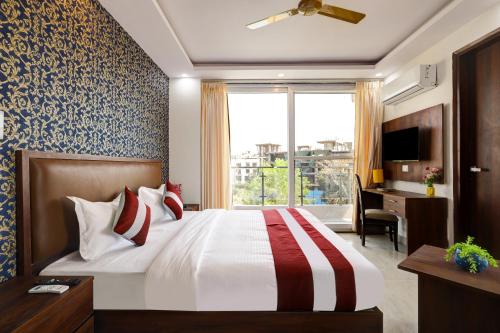 a bedroom with a bed and a desk and a window at Hotel The Venice- Near Indraprastha Apollo Hospital in New Delhi