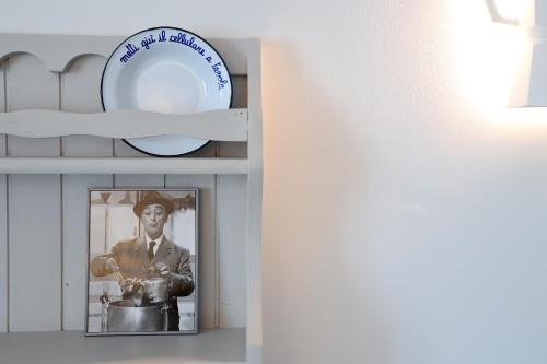 a plate on a shelf with a picture of a man at Casa CharmaRt in Asti