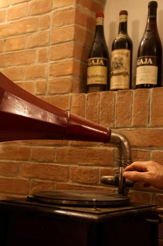 a person holding a bottle of wine on top of a toilet at Casa CharmaRt in Asti