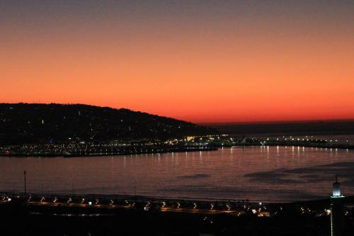 a sunset over a body of water with a city at 3 Appartements Vue sur Mer dans une maison indépendante in Tangier