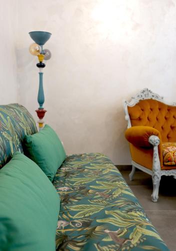 a living room with a couch and a lamp and a chair at Casa CharmaRt in Asti