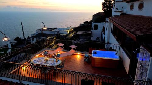 a balcony with a view of the ocean at sunset at Amalfi House Marlidia in Conca dei Marini