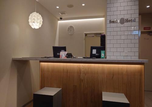 a reception counter in a store with a mirror at Smile Hotel Namba in Osaka