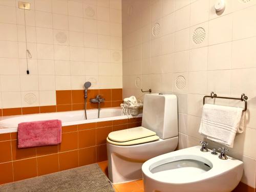a bathroom with a toilet and a bath tub at Villa Ines The elegance of the Tuscan countryside in Terranuova Bracciolini