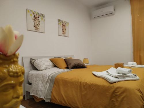 a bedroom with a bed with yellow sheets and pillows at Momaliar House in Campofelice di Roccella