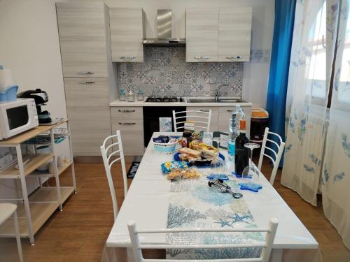 a kitchen with a white table and chairs at Momaliar House in Campofelice di Roccella