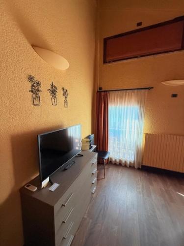 a living room with a television on a dresser at Podere Boschetto R&B in Bologna
