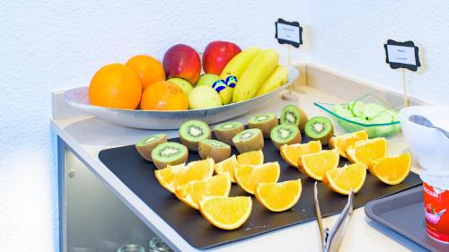 a table with a plate of fruit and a bowl of oranges at Hotel Eden Mar in Guardamar del Segura