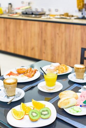 a table with plates of breakfast foods and cups of coffee at Hotel Eden Mar in Guardamar del Segura