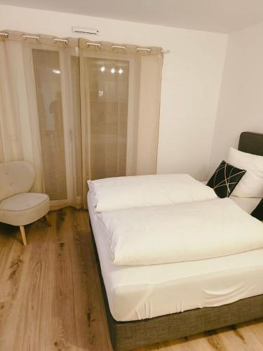 a small bedroom with a bed and a chair at Ferienwohnung Romeo, sehr zentral in Freiburg im Breisgau