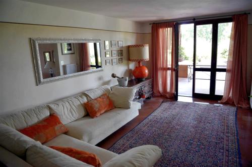 a living room with a white couch and a mirror at Villa Ines The elegance of the Tuscan countryside in Terranuova Bracciolini