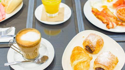 a table with plates of pastries and a cup of coffee at Hotel Eden Mar in Guardamar del Segura