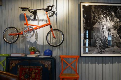 an orange bike is hanging on a wall at Nandha Hotel in Bangkok