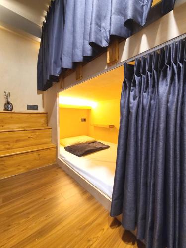 a bedroom with a bunk bed with blue curtains at LALA VIANCO BUSINESS Hotel in Busan