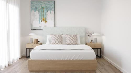 a white bedroom with a large bed with white sheets at Vieira Residence in Vieira de Leiria