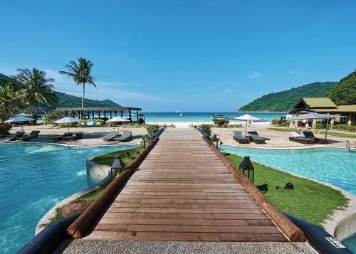 a boardwalk leading to the beach at a resort at The Taaras Beach & Spa Resort in Redang Island