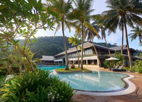 a resort with a swimming pool and palm trees at The Taaras Beach & Spa Resort in Redang Island