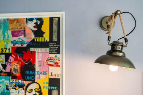 a lamp hanging on a wall next to a poster at Hotel Casa Art in Oreshak