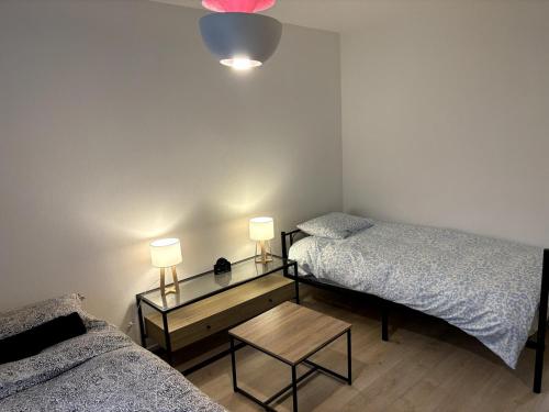 a bedroom with two beds and a table with two lamps at Le Moderne I Spacieux - 6 p - Hyper Centre in Annemasse