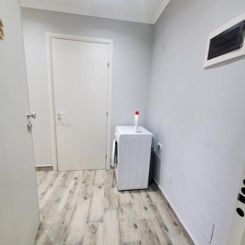 a white room with a refrigerator and a door at Urban Charm Lalzi in Draç