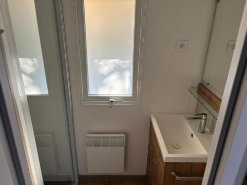 a bathroom with a sink and a window at Mobil home camping kerlann 6 personnes 2 chambres emplacement idyllique in Pont-Aven