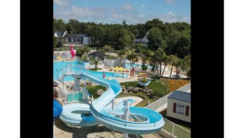 - une vue sur un parc aquatique avec un toboggan dans l'établissement Mobil home camping kerlann 6 personnes 2 chambres emplacement idyllique, à Pont-Aven