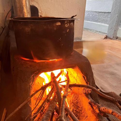 a pot sitting on top of a fire at Sunlight Homestay Mohana in Chakrāta