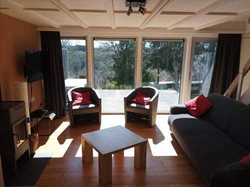 マルメディにあるTerrasses de Malmedy Chalet 141のソファと椅子2脚とテーブルのあるリビングルーム