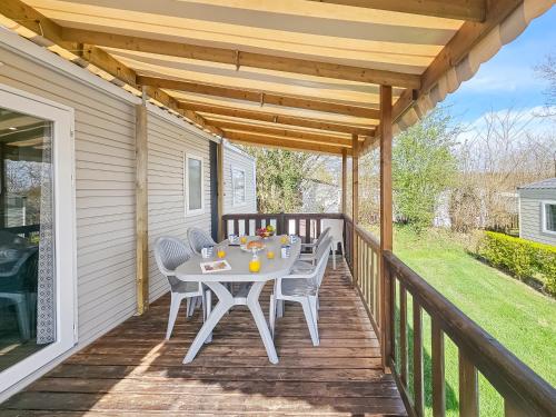 un patio avec une table et des chaises sur une terrasse dans l'établissement Escapade en famille au domaine de litteau, à Litteau