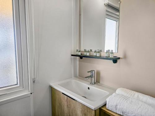 une salle de bain avec un lavabo et un miroir dans l'établissement Escapade en famille au domaine de litteau, à Litteau