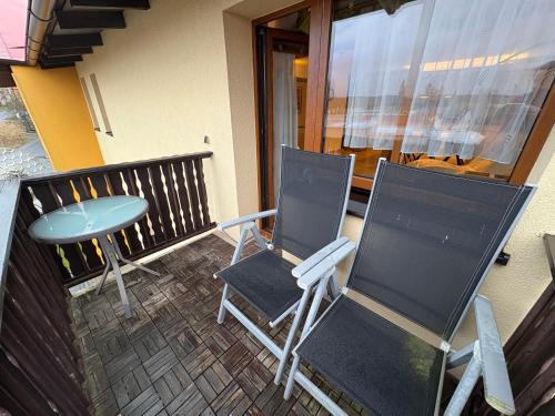 two chairs and a table on a balcony at Apartmán Lída in Františkovy Lázně