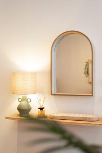 - une table avec une lampe et un miroir dans l'établissement OIQIA • Satori • Balinais, à Boulogne-sur-Mer