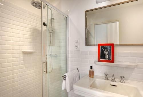 a white bathroom with a sink and a shower at Villa Casablanca Vichy Paris in Vichy
