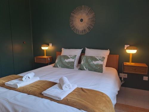 une chambre avec un grand lit avec des serviettes dessus dans l'établissement Au fil des Champs - Collection Idylliq, à Le Bosc-Roger-en-Roumois