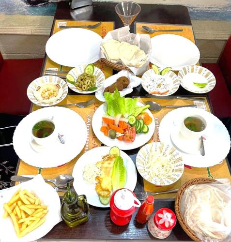 a table with white plates of food on it at مارينا للغرف الفندقية in Sohar