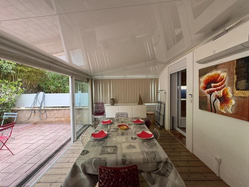 un salon avec une table et une grande fenêtre dans l'établissement Appartement 2ch, terrasses parking, 50m de la plage, à Sanary-sur-Mer