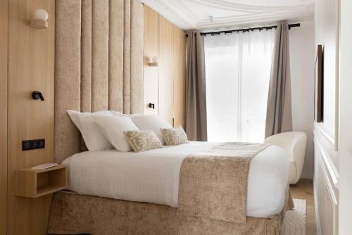 une chambre avec un grand lit blanc avec une fenêtre dans l'établissement Chic Apartment with AC 3BR 6P Palais Garnier, à Paris