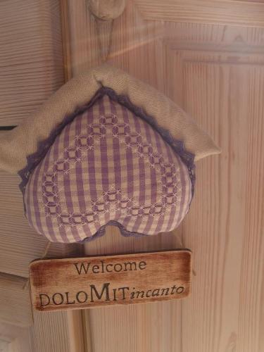 a wooden door with a welcome sign on it at B&B Dolomitincanto in Cesiomaggiore