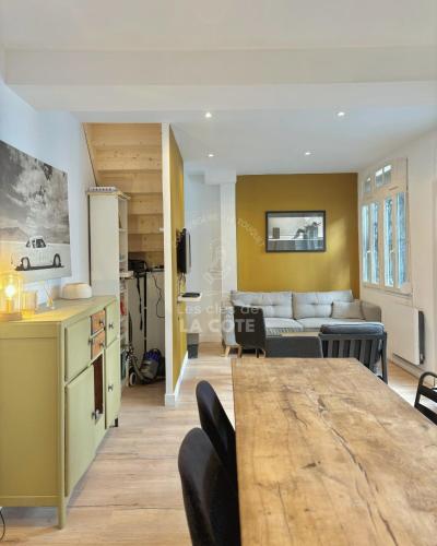 une cuisine et un salon avec une table et un canapé dans l'établissement Maison 