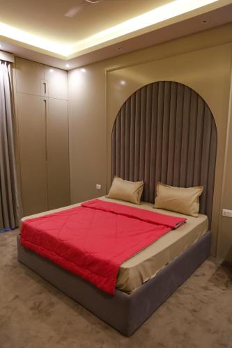 a bedroom with a large bed with a red blanket at The Luxe Life 2BHK at Supernova in Noida
