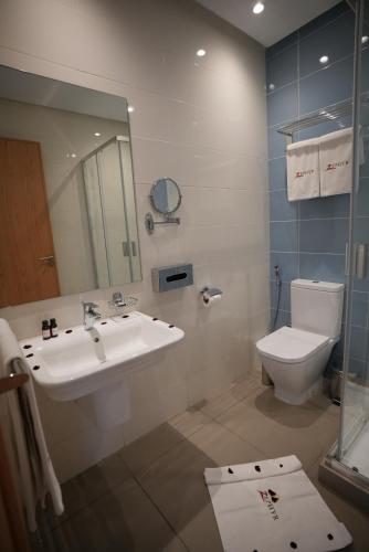 a bathroom with a sink and a toilet and a mirror at Zephyr Agadir in Agadir