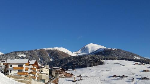 a ski resort with snow covered mountains in the background at Pension Sonnenhof in Maranza
